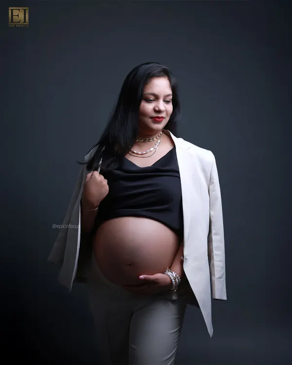 A powerful "boss-mama" look, pairing a white blazer with a bare bump for a confident and modern maternity statement.