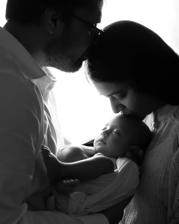 A beautiful and artistic black and white silhouette of new parents holding their baby. This is a classic pose we love to create during newborn family sessions.