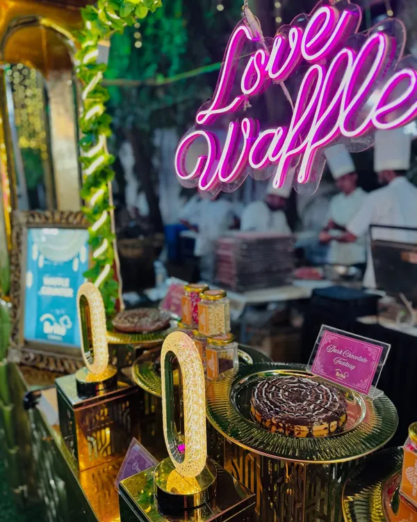 My "Love Waffle" station, a crowd favorite, featuring a fun neon sign and a variety of freshly made waffles.