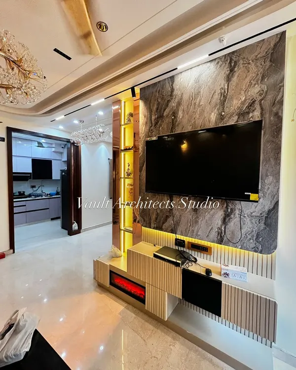 This living area showcases our expertise in creating luxurious and functional spaces. We designed this bespoke TV unit with a striking marble-effect backdrop, integrated ambient lighting, and fluted paneling to create a modern classic focal point for the home.
