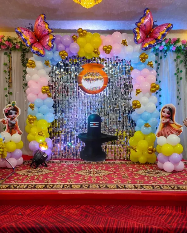 A colorful naming ceremony decoration featuring a shimmer wall, pastel balloon pillars, and Cocomelon character cutouts.