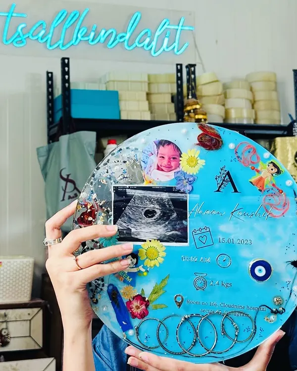 This 11-inch circular frame is a treasure trove of a baby's firsts. It includes the umbilical cord, first ultrasound, silver kadas, rakhi threads, and birth details. It’s a beautiful way to tell the story of your baby's arrival.