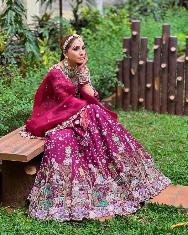 This stunning magenta lehenga is paired with one of the beautiful emerald and polki sets available for rent.