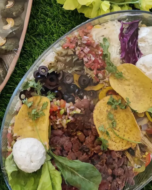Our layered Burrito Bowl is a complete meal, perfect for festive orders. It features layers of rice, beans, salsa, corn, olives, and cheese, all packed into one convenient and delicious platter.