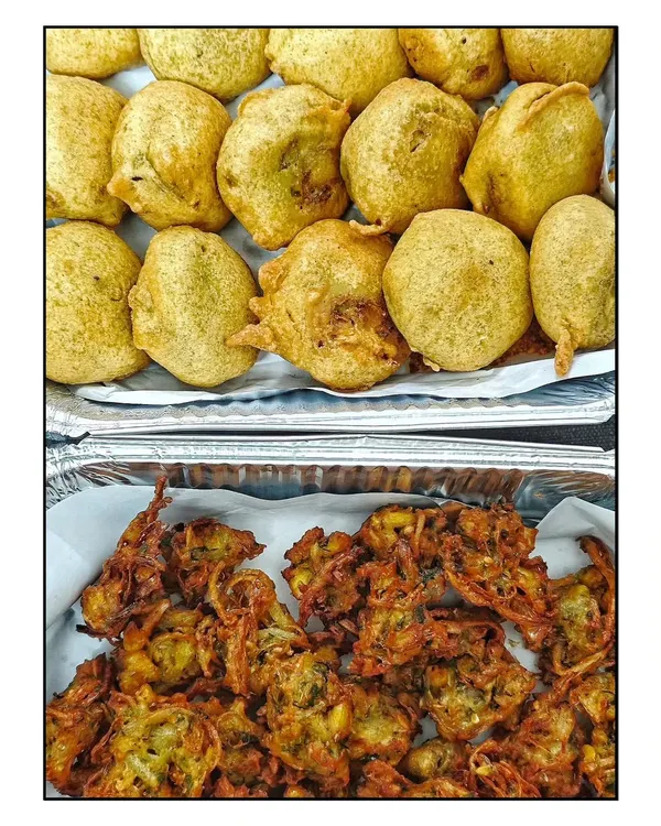 A classic combination for a rainy day or any evening. Freshly fried, hot Batata Vadas and crispy Onion Bhajiyas, also known as Khekda Bhaji, served as an evening snack.