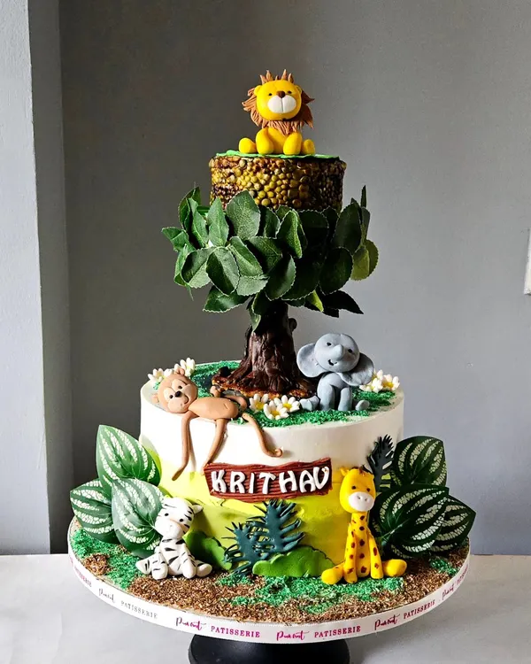 This showstopper jungle cake features a real rotating tier. The top tier, with the lion, actually spins, creating a dynamic and exciting centerpiece. All animals and the tree are handcrafted and edible.