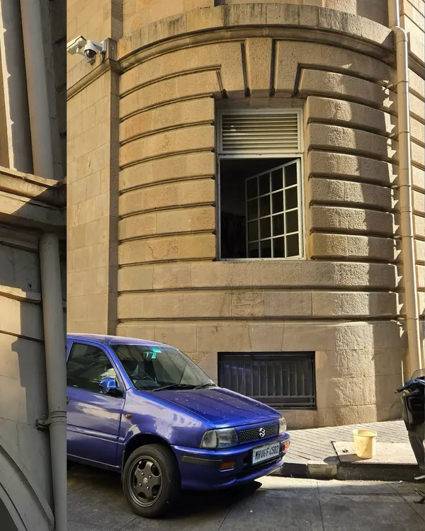 Fort owns the mornings in South Bombay. The early sunlight brings out every detail of the heritage architecture, making the stone facades ripen in the sun. A purple car adds a perfect pop of modern color.