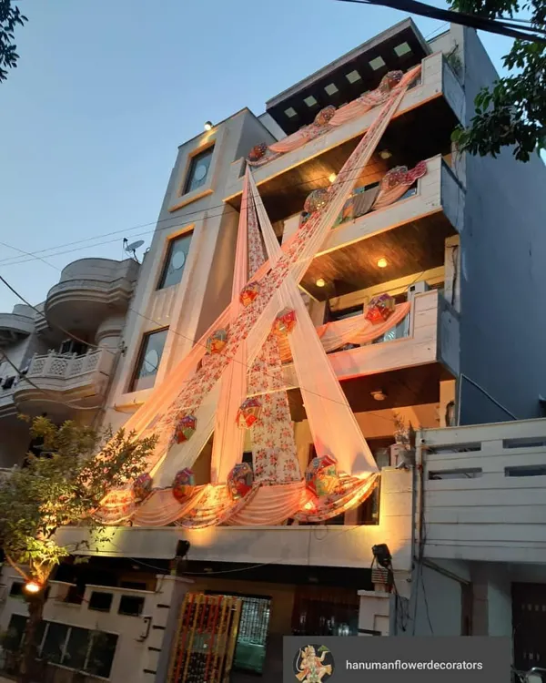 A full building facade decoration for a day event. I use elegant peach drapes and floral baskets to create a festive look that makes the entire house feel like part of the celebration.