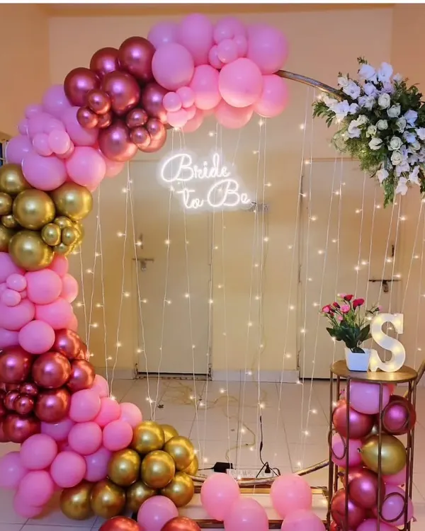 A beautiful 'Bride to Be' setup perfect for a bachelorette party or bridal shower. I used a circular frame with a pink and gold balloon arch, fairy lights, and a neon sign to create this elegant photo corner.