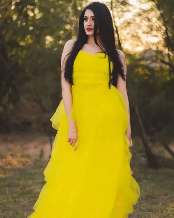 This vibrant yellow tiered tulle gown is a fantastic choice for a portfolio shoot. Its bright color and playful layers stand out beautifully in natural, golden-hour lighting.