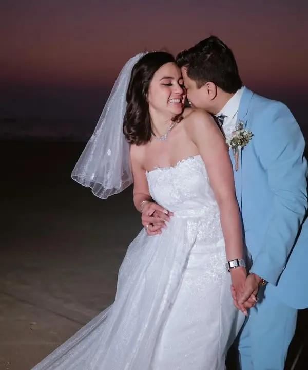 A beautiful moment from a Catholic wedding on a Goa beach. The groom's gentle kiss and the bride's happy smile capture the joy of the day.