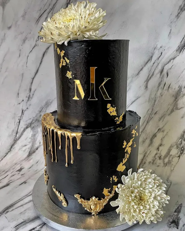 This two-tier black and gold cake is a perfect example of my modern and luxe style. I used a deep black buttercream to create a dramatic canvas, then added a custom gold monogram, delicate gold leaf accents, and a striking gold drip effect for a truly showstopping centerpiece.
