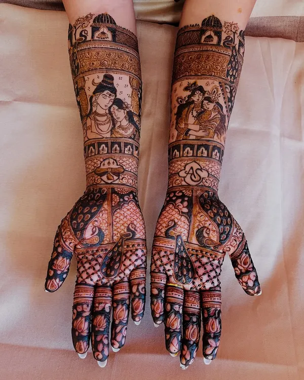 This full bridal mehendi showcases my expertise in detailed figure work, featuring portraits of Shiv-Parvati and Radha-Krishna. The design combines divine storytelling with intricate patterns like peacock motifs and delicate lotus flowers on the fingers.