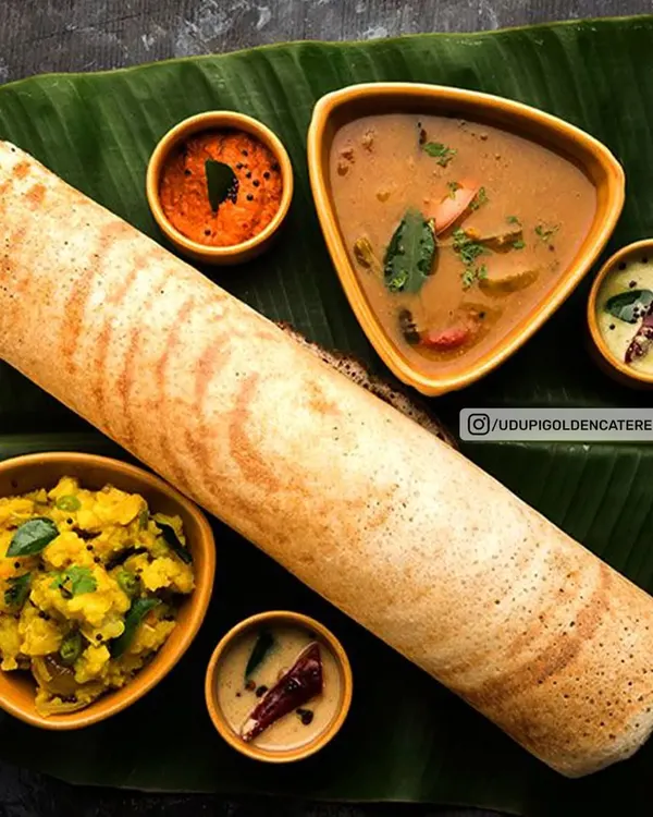 A perfectly prepared Masala Dosa, presented traditionally on a banana leaf with potato filling, sambar, and a variety of chutneys. A centerpiece for any South Indian breakfast spread.