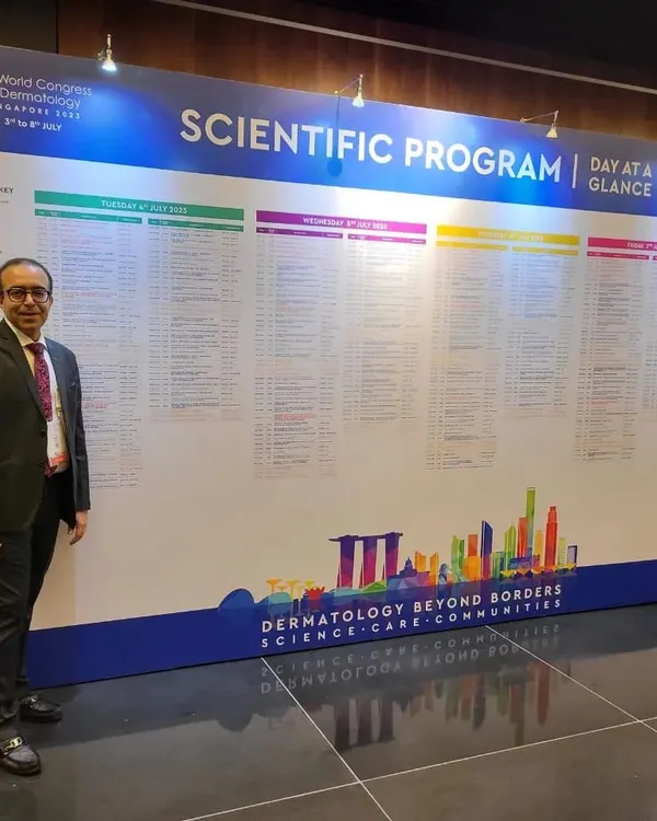At the 25th World Congress of Dermatology in Singapore, standing before the extensive scientific program. Attending these events is crucial for learning about global advancements and bringing the best practices back to my patients in Delhi.
