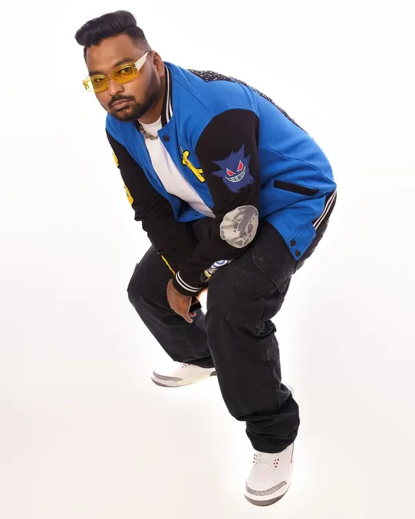 A fresh press shot showcasing my style. The custom varsity jacket and yellow-tinted glasses are part of my signature look.