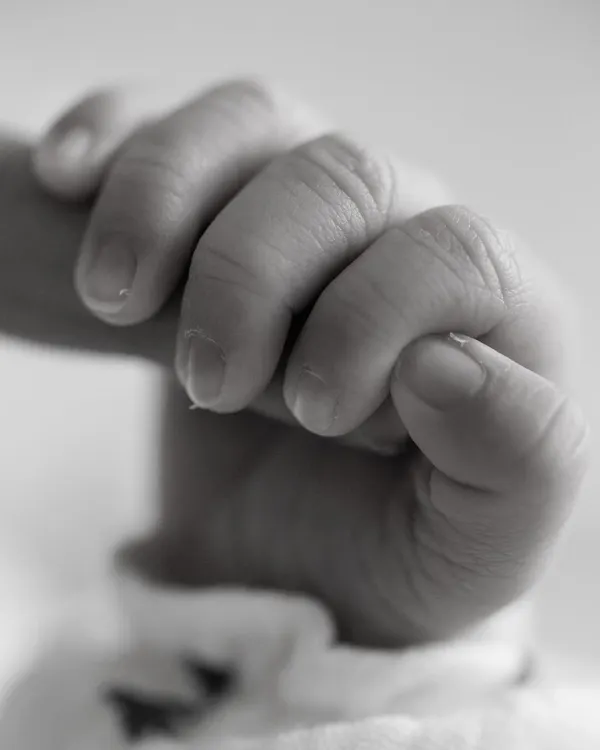 Holding my heart forever. A newborn's grip is so strong and so full of trust. This macro shot of a tiny hand wrapped around a finger is a powerful symbol of your new bond.