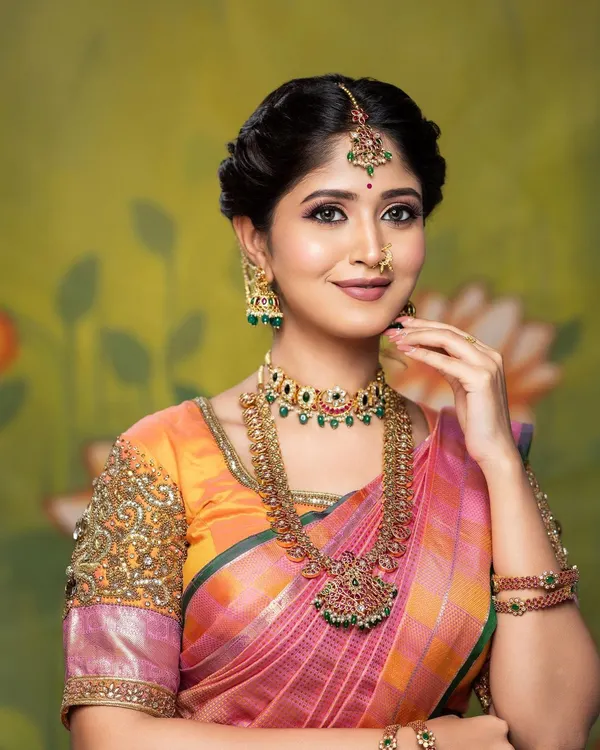 This is the quintessential South Indian bridal look I love to create. The makeup features a flawless, dewy base with soft, defined eyes and a classic lip color, perfectly complementing the vibrant silk saree and traditional gold jewellery.