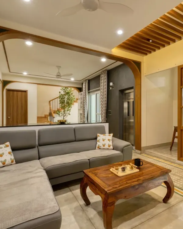 A view of the Villa 17 living room, where a custom L-shaped sofa is framed by a wooden archway, creating an inviting and connected space.