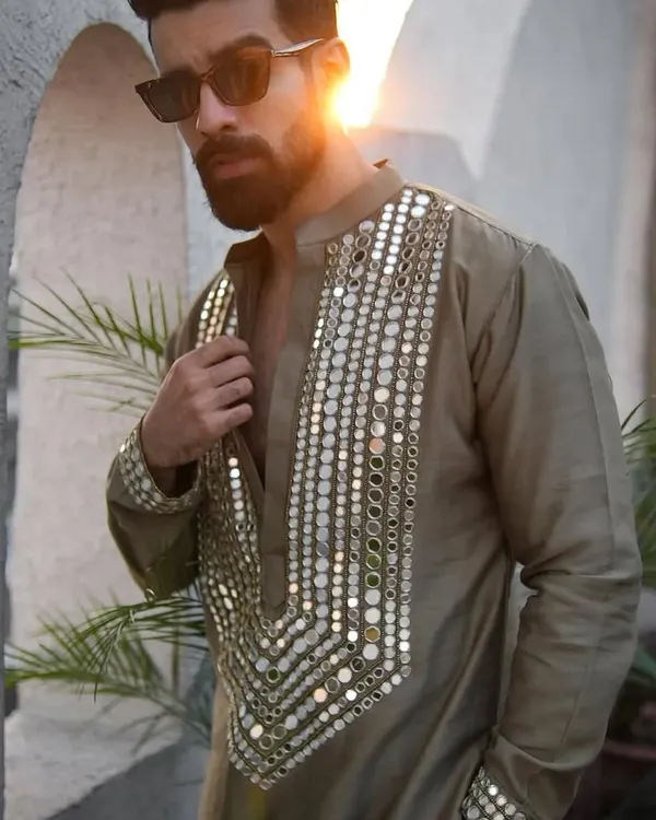 A standout piece for a Mehndi or Haldi ceremony. This olive green kurta is heavily embellished with a mosaic of real mirrors on the neckline and cuffs, designed to catch the light and everyone's attention.