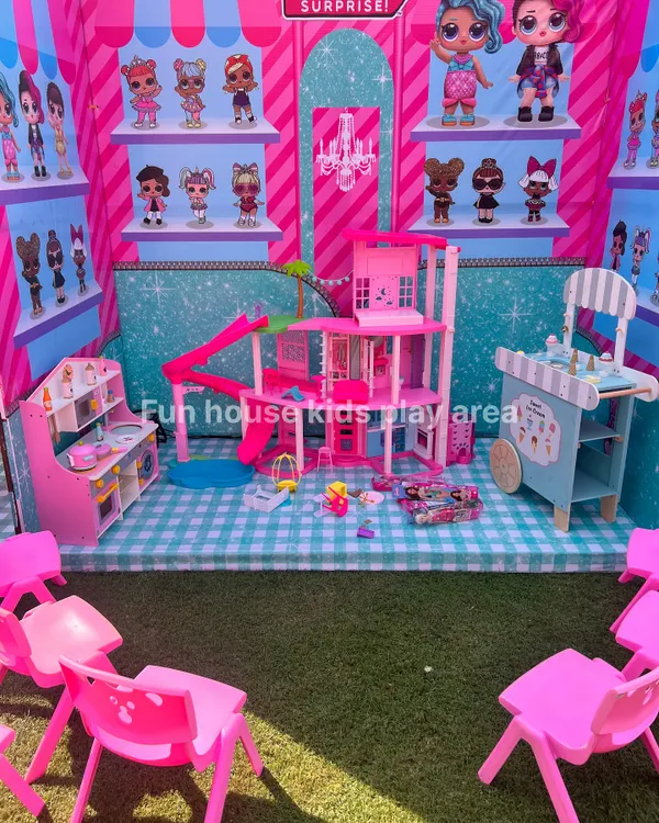 A complete imaginative play corner set up for an LOL Surprise and Barbie themed party. This setup includes the Barbie Dream House, a pretend play kitchen, an ice cream cart, and kid-sized seating.