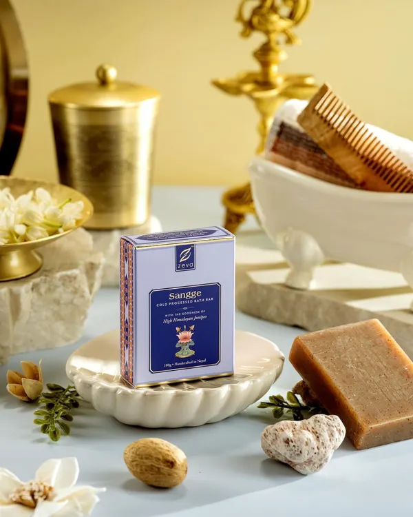 An elaborate setup for Zeva's 'Sangee' bath soap, featuring traditional bathing elements like a miniature tub, comb, and fresh jasmine. This composition evokes a sense of luxurious, time-honored self-care rituals.