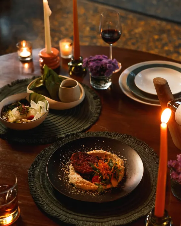 For Valentine's Day, we create an atmosphere of pure romance. This table, set for two with candlelight and a glass of red wine, showcases our special set menu designed for an unforgettable evening.