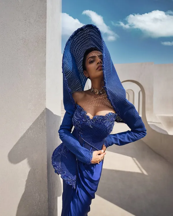 This sculpted mesh gown in Active Blue is a study in form and presence. I designed the architectural hood to frame the face, creating a silhouette that is both powerful and mysterious. It is for the woman who commands attention not with noise, but with the quiet confidence of her style.