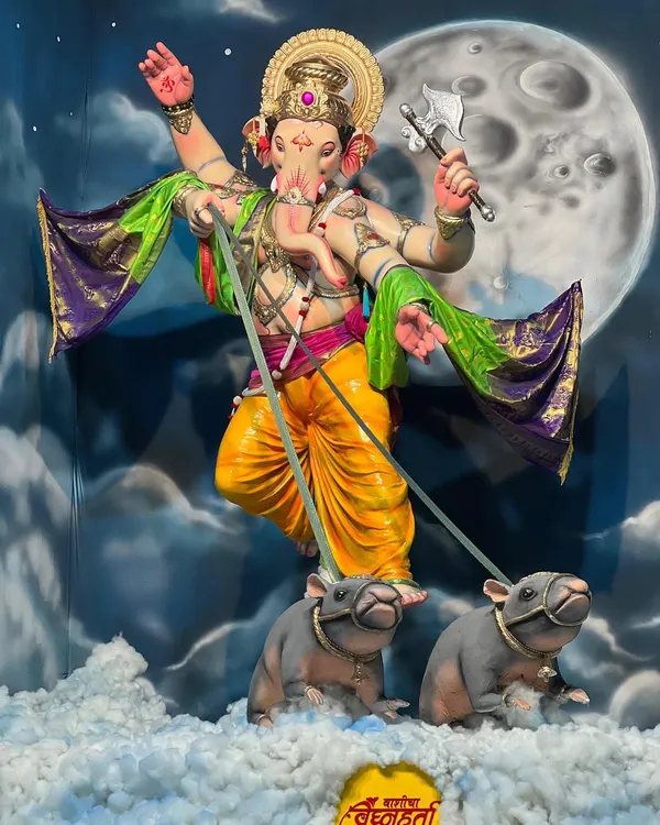 The final look of this celestial-themed Ganpati pandal. The murti appears to be floating through the clouds, an effect created by the hand-painted backdrop of the moon and a floor covered in cotton to look like clouds.