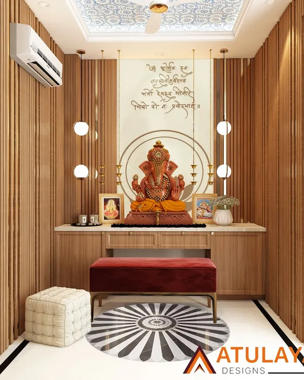 A modern pooja room with vertical wooden slats, a marble platform for the deity, and elegant pendant lights resembling diyas.