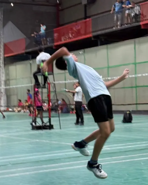 This is the result of dedicated training. A player executes a powerful jump smash, a technique we perfect through drills focusing on timing, footwork, and explosive strength.