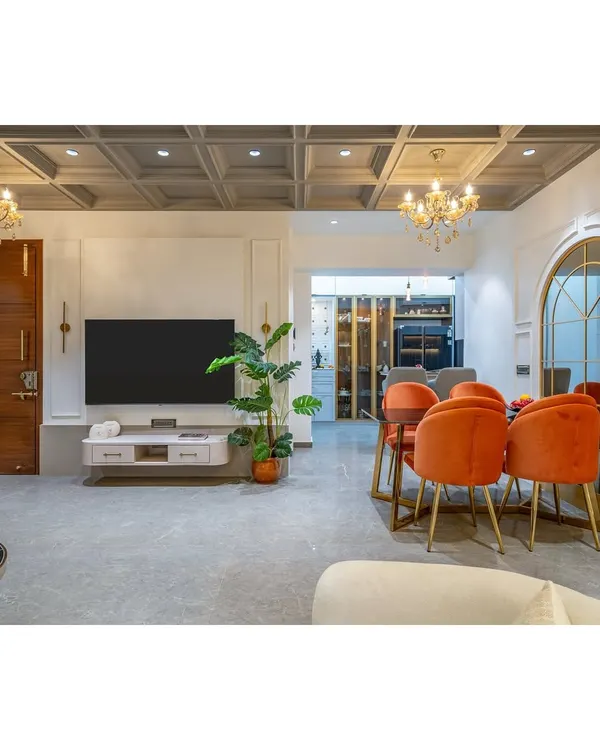 Our design philosophy in a single frame. This open-plan living and dining area combines neoclassical elegance with modern comfort, featuring a coffered ceiling, grand archways, and plush furnishings. We create spaces that are perfect for both quiet family evenings and elegant entertaining.