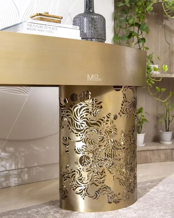 A detail shot of the Ferrosa Console's base. This view highlights the intricate, laser-cut Jaali-inspired pattern in a brushed antique gold finish, showcasing how we reimagine traditional architectural elements in a contemporary form.
