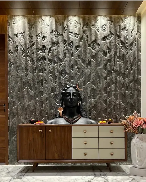 For this entryway in Jodhpur, I designed a custom console table and a textured stone-chip wall panel. The Adiyogi bust creates a serene and powerful focal point.