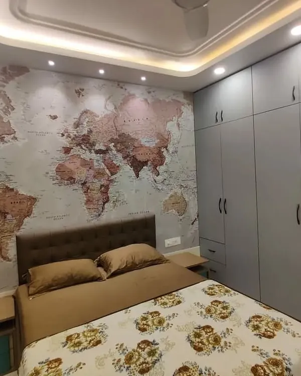 We designed this bedroom as a complete experience, centered around a striking world map statement wall for our travel-loving client. The design integrates floor-to-ceiling matte grey wardrobes for ample storage, a comfortable tufted headboard, and multi-level ceiling cove lighting to create a warm, inviting atmosphere.