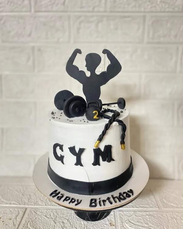 Strong mind, stronger body. A blueberry cake for the gym freak in your life, complete with fondant dumbbells, kettlebells, and a bodybuilder silhouette.