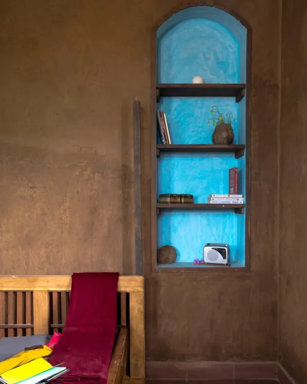 The plain mud walls of the Doddaballapura house are punctuated by an arched niche with a vibrant blue oxide finish. This shows how simple, natural materials can be combined to create moments of beauty and surprise.
