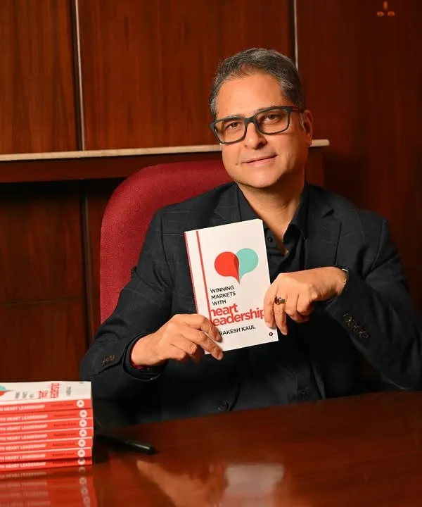 A classic author portrait for Rakesh Kaul, pictured with his book "Winning Markets with Heart Leadership". This shot is perfect for a book launch or press release.