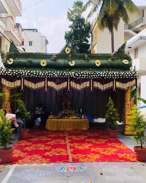 A video showing the construction and final look of a traditional chapra for a housewarming. The structure is made from palm leaves and decorated with marigold flowers and other auspicious items.