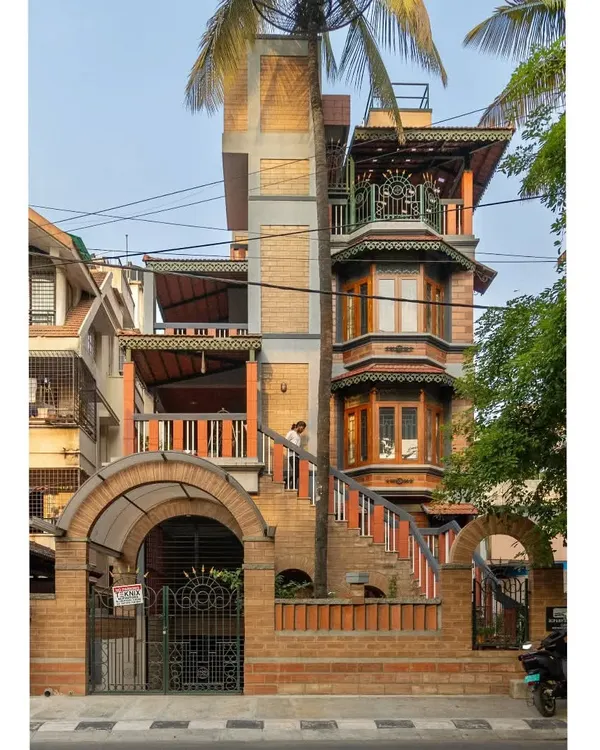 This home in Basavanagudi, Bangalore, is a testament to our belief in complex, layered design that feels organic and rooted. We integrated exposed earth blocks, traditional bay windows, and multiple balconies, even allowing a palm tree to grow through the structure, truly merging the building with its landscape.