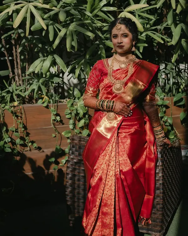 A classic South Indian bridal look. I paired her bold red Kanjivaram silk saree and intricate temple jewellery with a timeless makeup look: a soft matte base, defined eyes, and a rich red lip.