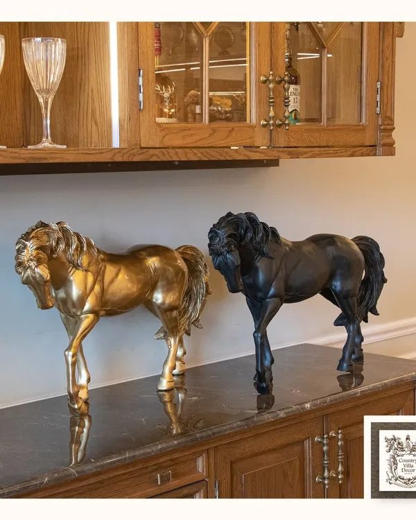 This pair of horse sculptures, one in gold and one in black, exudes power and elegance. Placed on a dark marble-topped sideboard, they create a stunning and luxurious focal point.