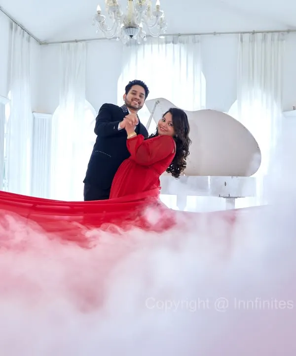 We use props like a flowing red fabric and a smoke machine to create dramatic, high-fashion looks in our elegant white piano studio.