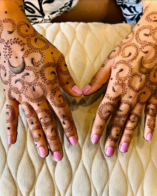 A unique Karwachauth design featuring a repeating crescent moon pattern. The delicate dots and swirls add a modern touch to the traditional festival henna.