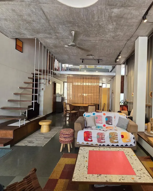 My home and studio is an open-plan loft space, where living and working areas flow into one another. The design uses a simple palette of exposed concrete, steel, and Kota stone, with a floating staircase that keeps the space feeling light and connected.