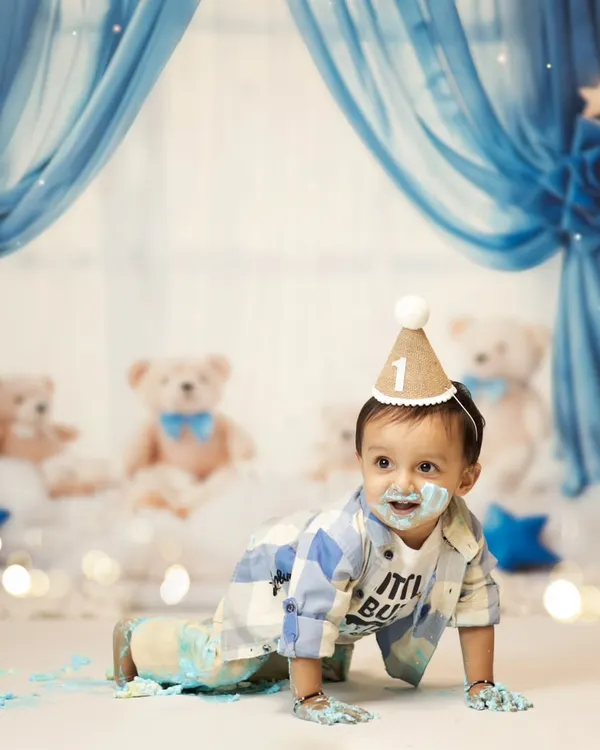 Let the mess begin! This little boy is having the best time during his first birthday cake smash. The blue and white teddy bear theme makes for such an adorable setup.