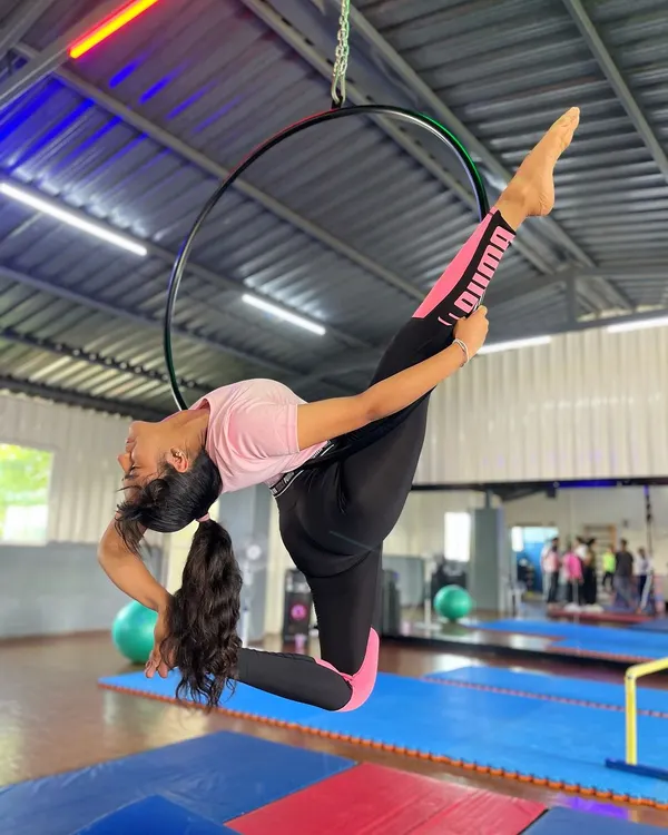 Finding grace in the air. This student showcases a stunning pose on the aerial hoop, a testament to the strength and flexibility we build in our aerial arts program.