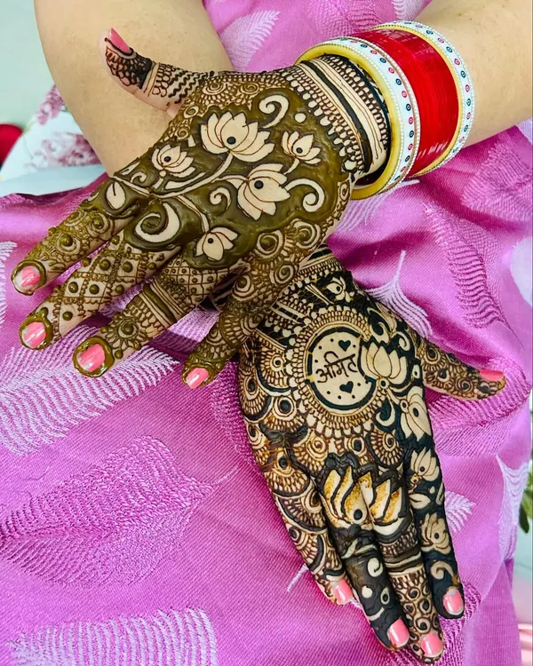 A beautiful example of personalized festive mehndi. This design features the name 'Anil' in a central mandala, surrounded by lovely lotus flowers, perfect for a Karvachauth celebration.