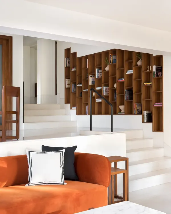 The three levels of this home are connected by a custom, climbing bookcase that serves as the focal point. The wide steps double as informal seating, making the entire transitional space functional and inviting.