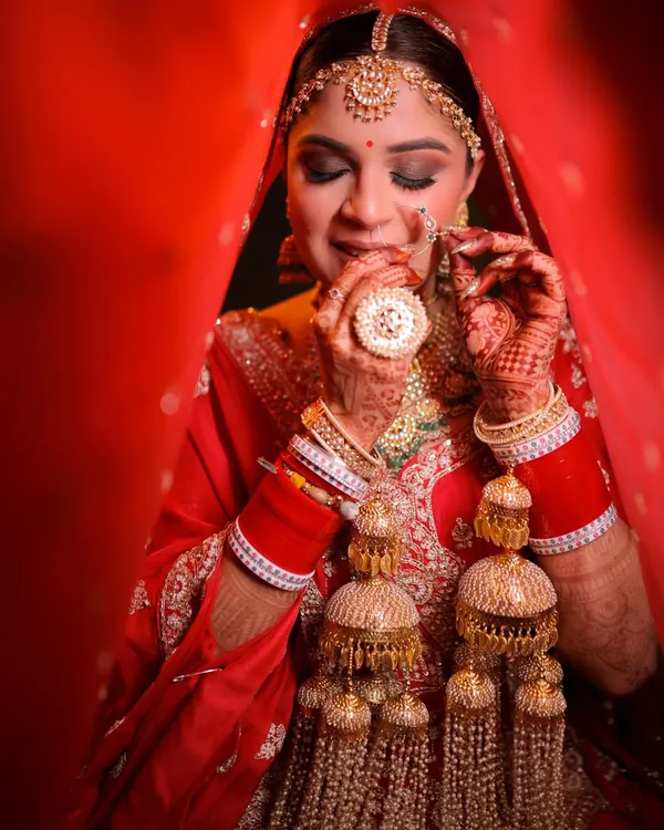 A classic bridal portrait. Here, I focused on creating a flawless base that lasts through all the ceremonies, paired with traditional red and gold tones on the eyes and lips. The final look is timeless, highlighting her beautiful features and ornate jewelry.